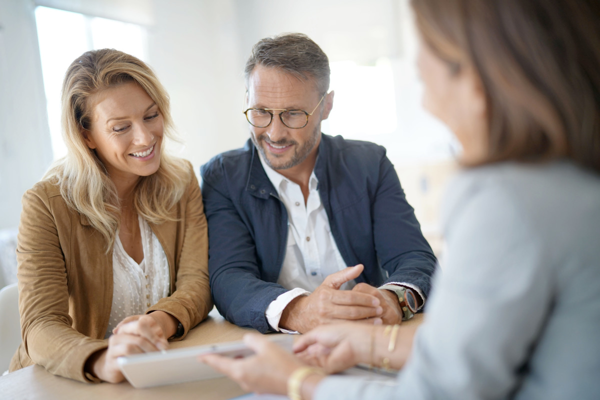 aides à l'achat immobilier neuf - Un couple en rendez-vous à la banque pour une demande de prêt immobilier