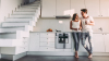 taux de crédit immobilier bordeaux - Un couple se tenant dans une cuisine moderne dans un logement neuf