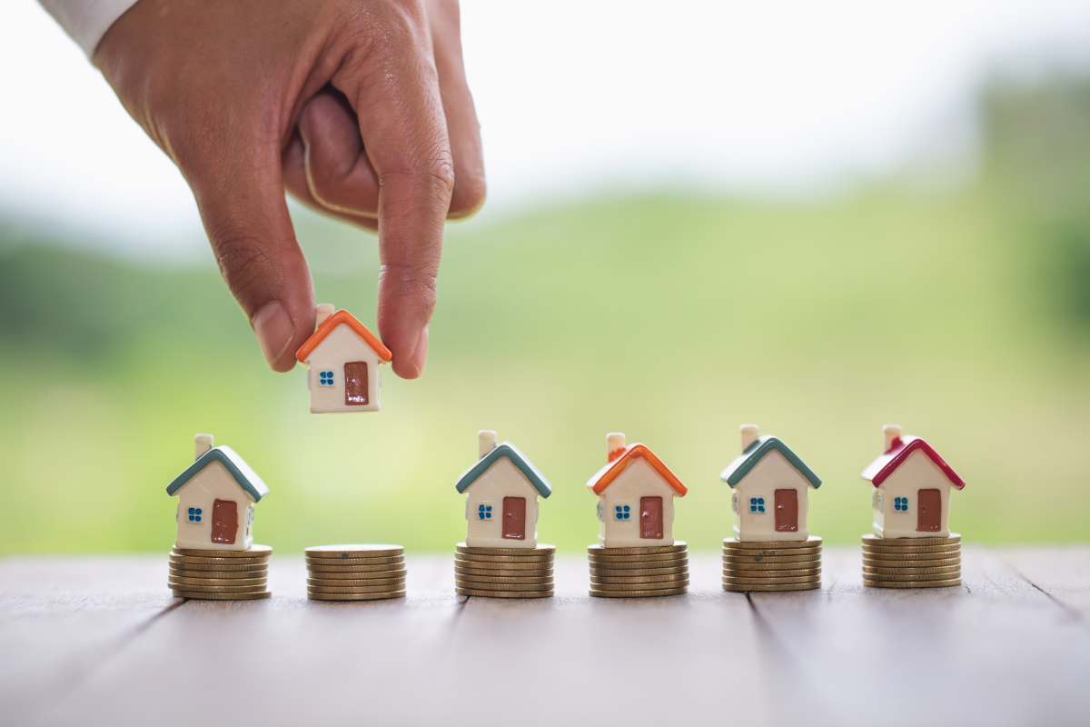 des petites maisons sur des piles de pièces