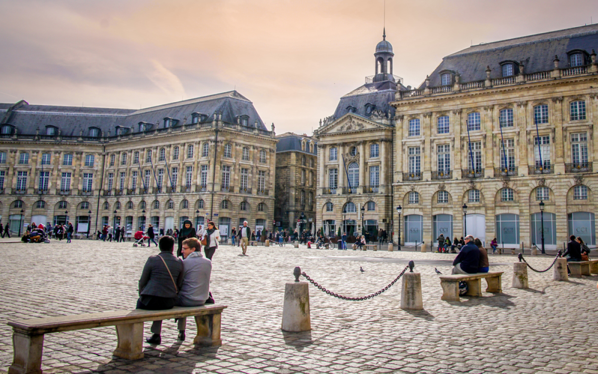Renégocier prêts immobiliers - couple assis sur un banc sur la place de la Bourse à Bordeaux
