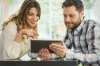 investir dans l'immobilier - Un couple navigue sur internet via une tablette numérique