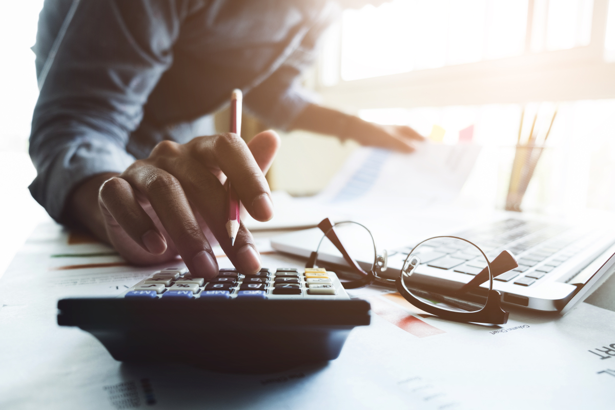 PTZ prolongé - une femme calcule ses revenus avec une calculette et son ordinateur