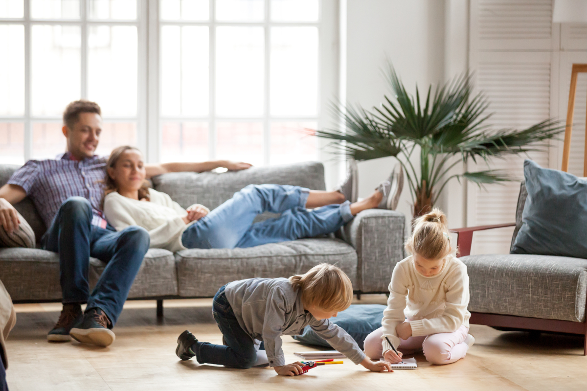 Gestion locative Bordeaux – Un couple en train de regarder ses enfants jouer dans un salon