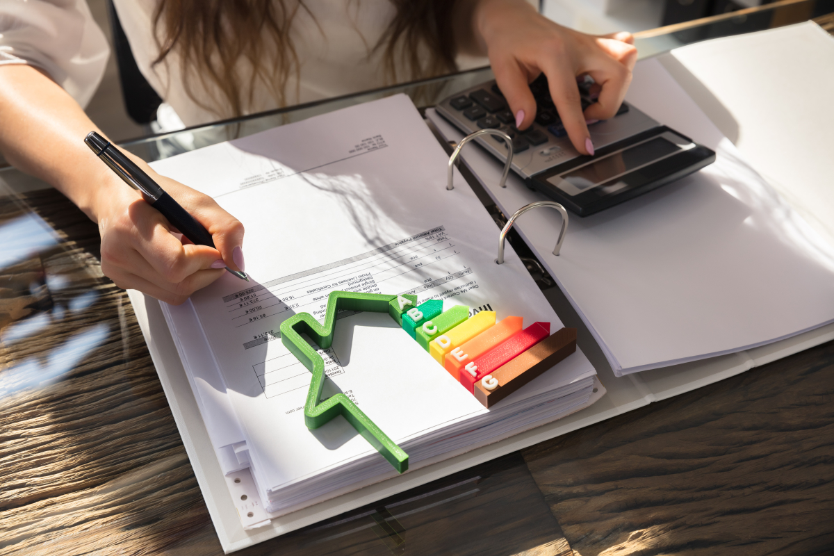 Quels avantages à habiter dans de l’immobilier écologique ? Immobilier écologique - Femme calculant ses factures d’électricité et la performance énergétique