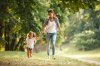 Où vivre autour de Bordeaux en famille – Jeune mère et sa fille se promenant dans une forêt verdoyante