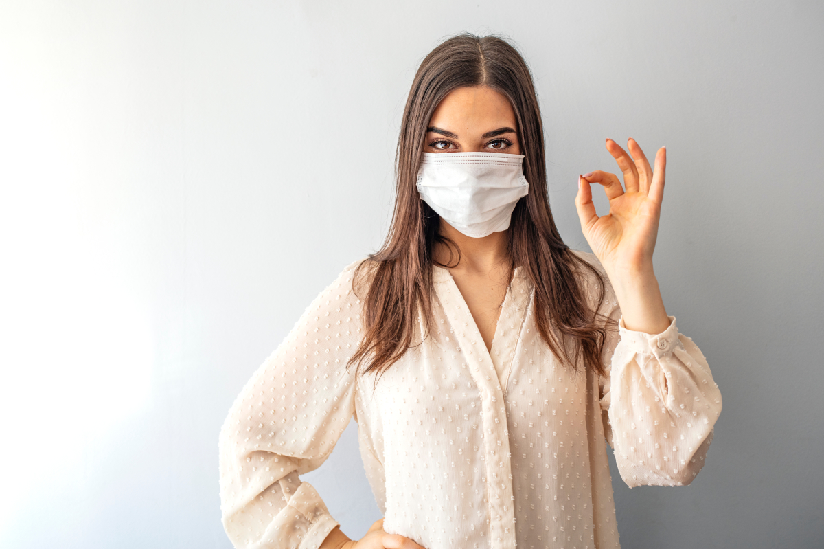 Les visites peuvent être effectuées dans le respect des gestes barrières Pass sanitaire et location – Jeune femme portant un masque chirurgical