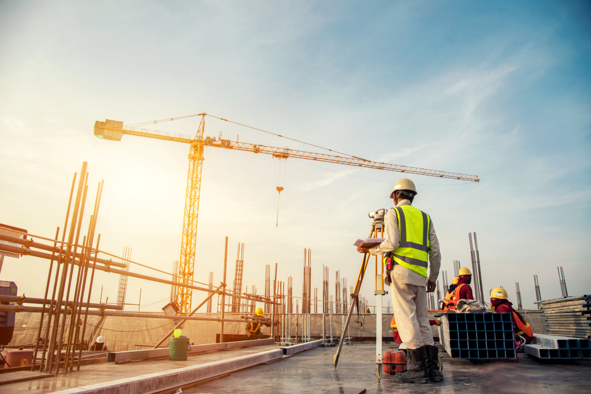 Nouveau Ministre du Logement 2024 — Ingénieur en bâtiment sur le toit d'un immeuble en construction avec grues en arrière plan