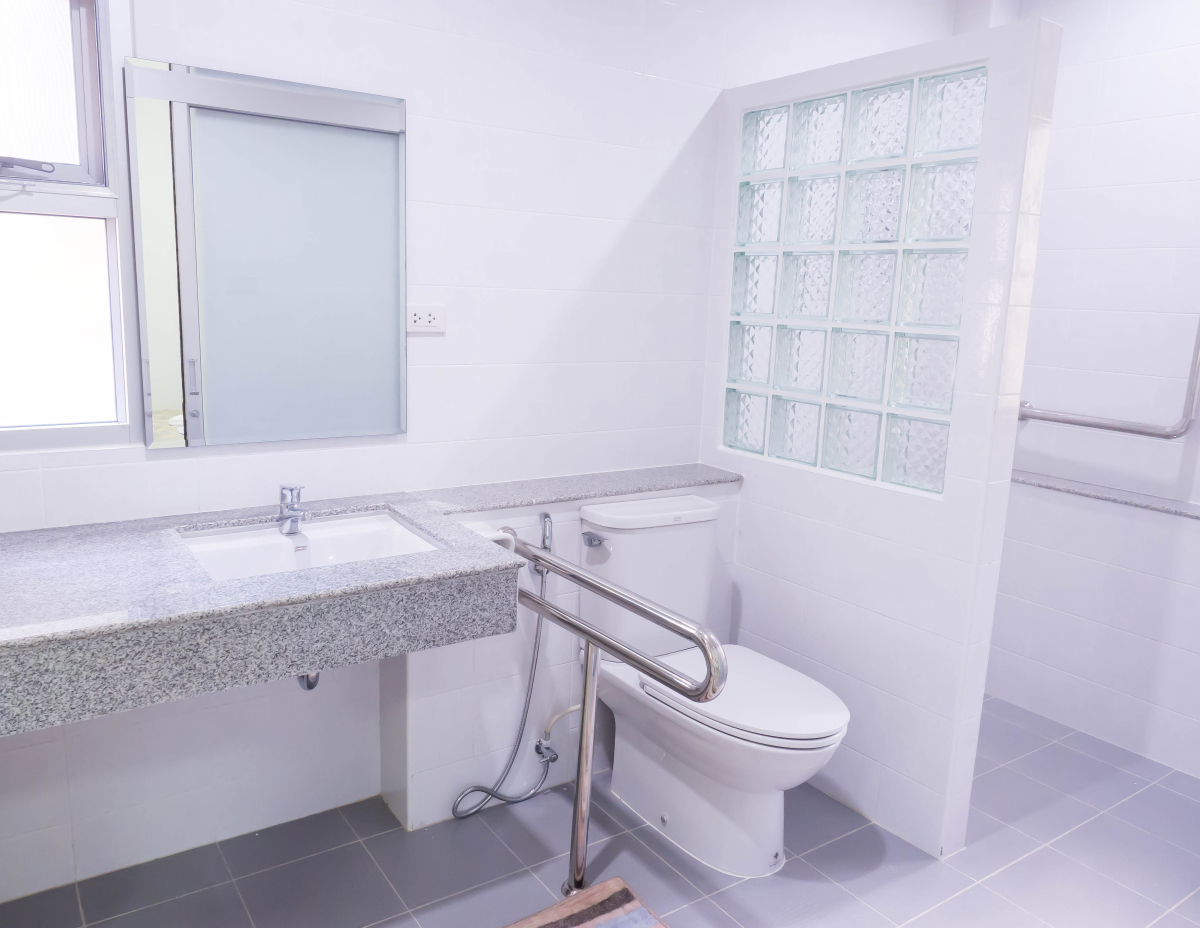 MaPrimeAdapt — Une salle de bain où a été installée une rampe pour faciliter l’usage des toilettes