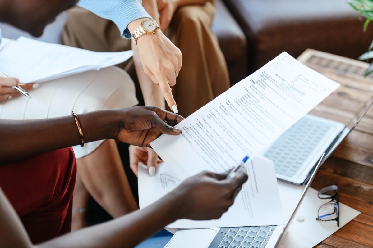 Créer une SCI pour son investissement immobilier neuf à Bordeaux Constituer une sci bordeaux immobilier neuf – des personnes discutent autour d’un projet commun et se renseignent via la documentation