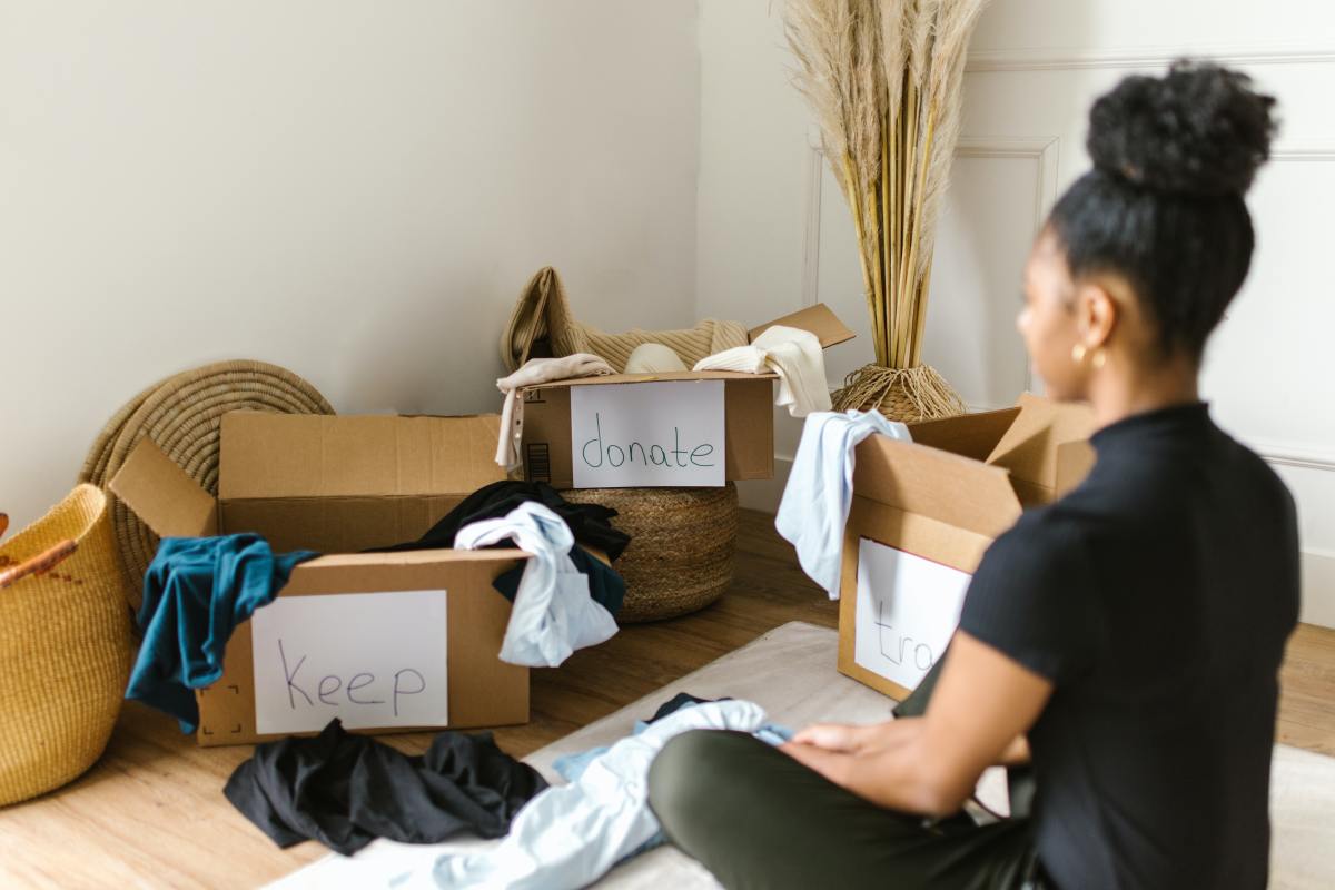 Home staging – une jeune femme est face aux cartons contenant des affaires à donner