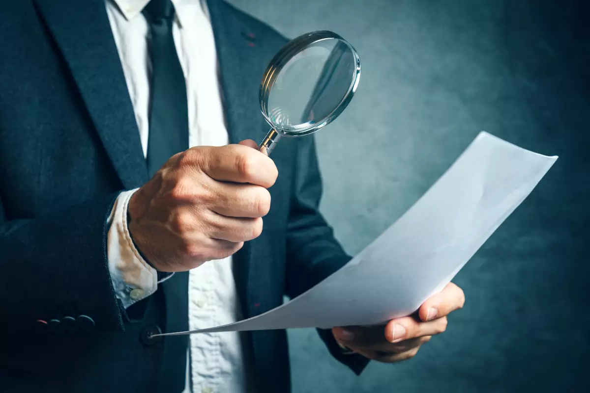 Un homme de loi observe un document juridique à la loupe