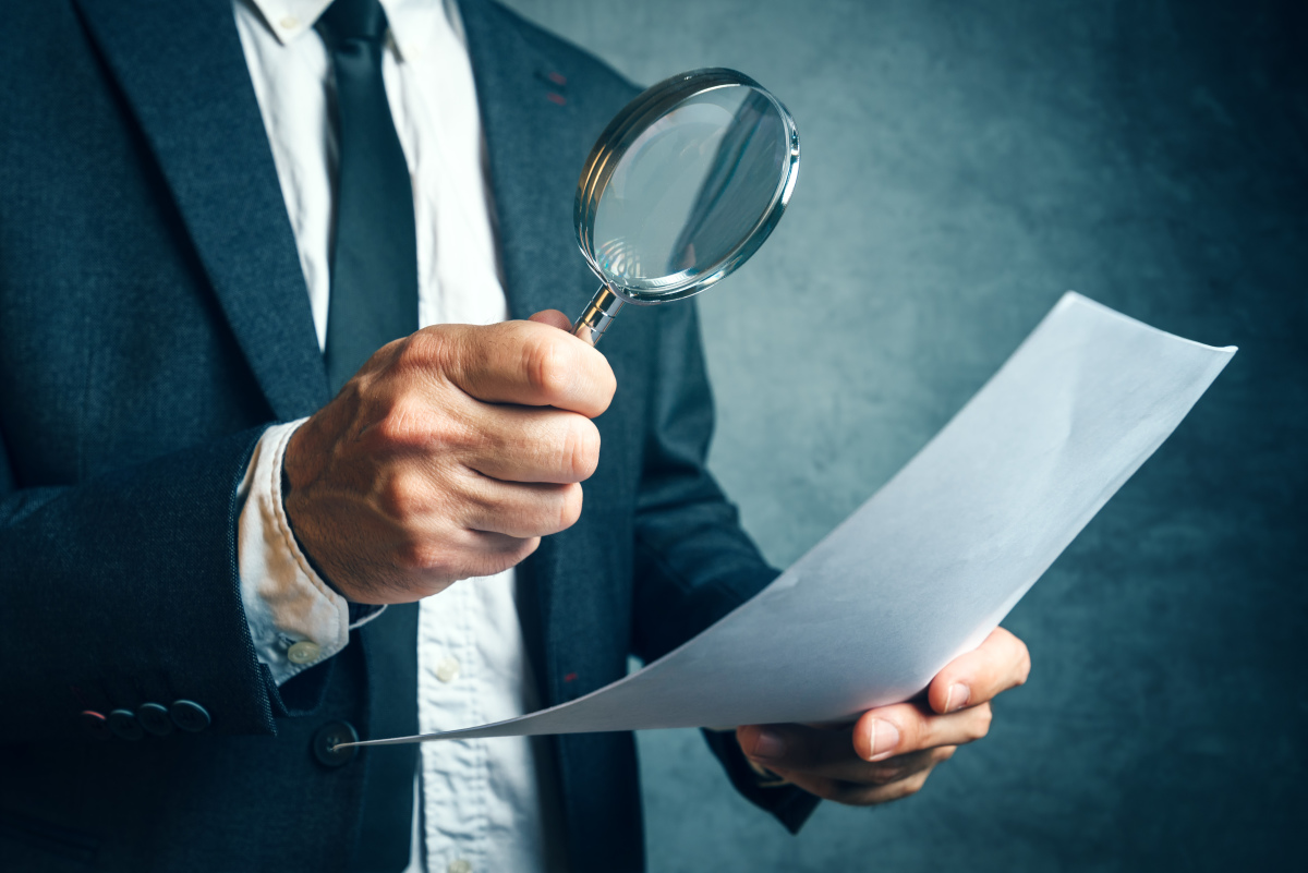  Un homme de loi observe un document juridique à la loupe