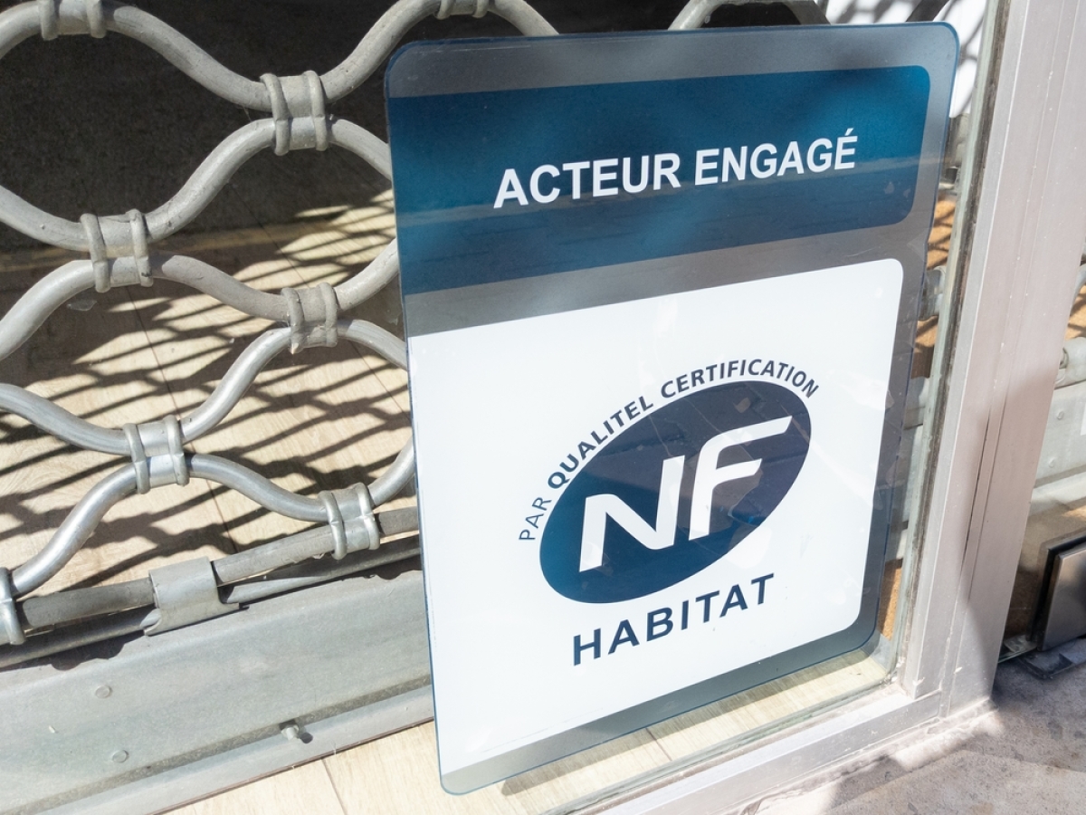NF HAbitat est un label très fréquement rencontré dans les programmes immobiliers neufs un panneau label NF habitat en bas d’un rideau métallique de commerce