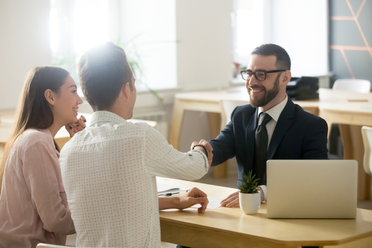 Pour bénéficier de frais de notaire réduits, il faut remplir quelques conditions Frais de notaire achat immobilier neuf – un couple d’acheteurs en rendez-vous avec un professionnel de l’immobilier