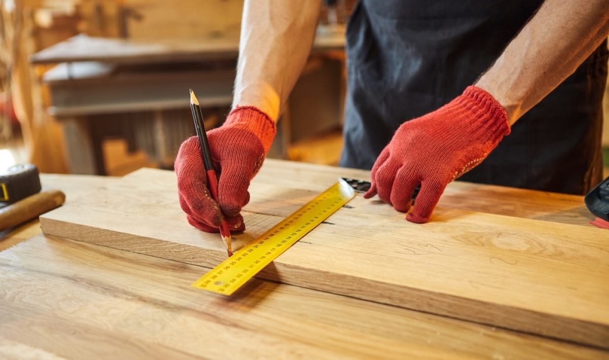Travaux Modificatifs Acquéreurs — Un charpentier en train de couper du bois
