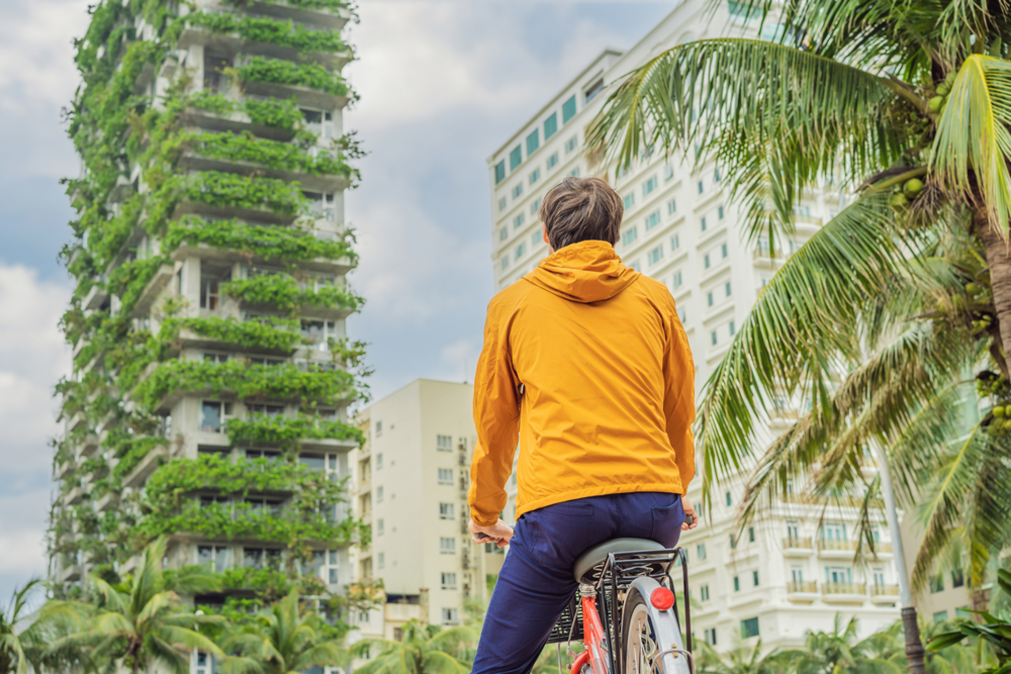 Un cycliste admire une tour végétalisée