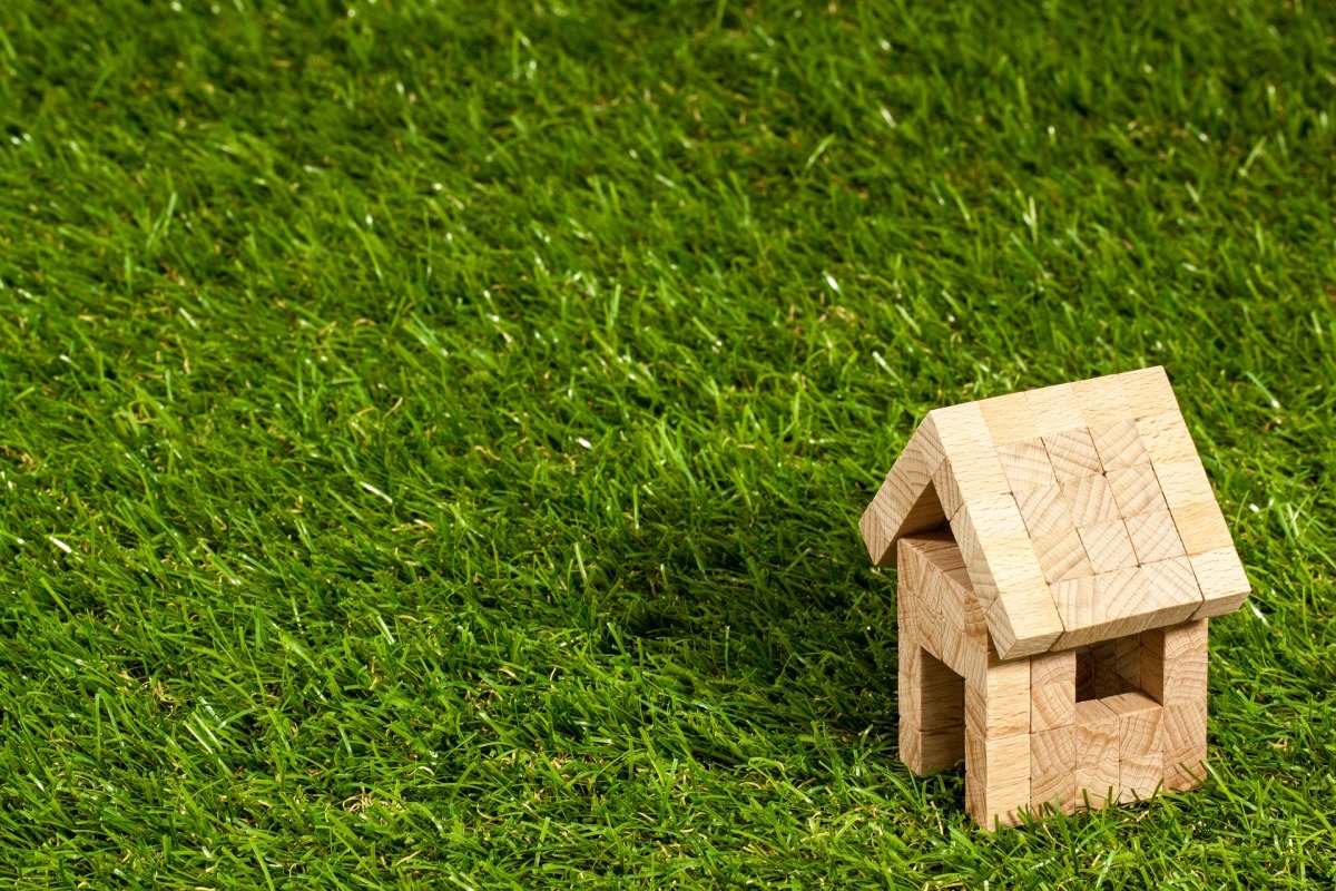 Invesstissement immobilier Bordeaux – Une maison miniature en bois sur du gazon