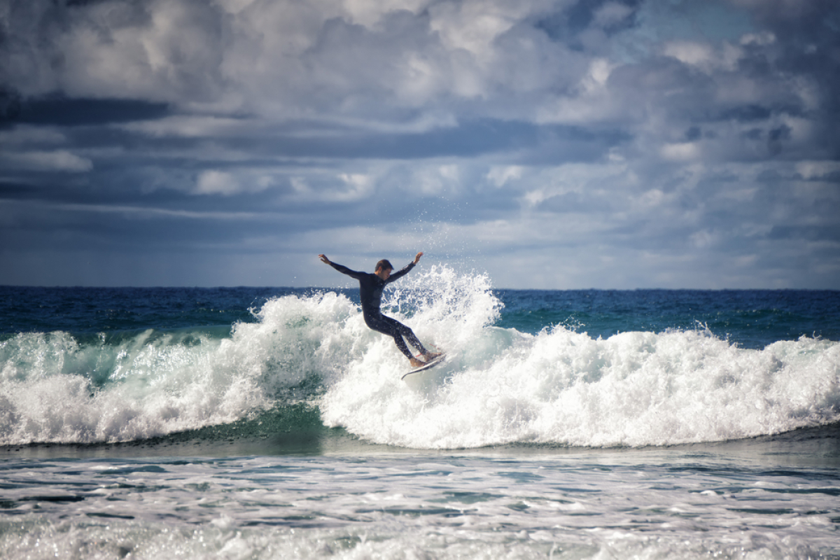 investir à Biscarrosse – un surfeur sur une vague à Biscarrosse