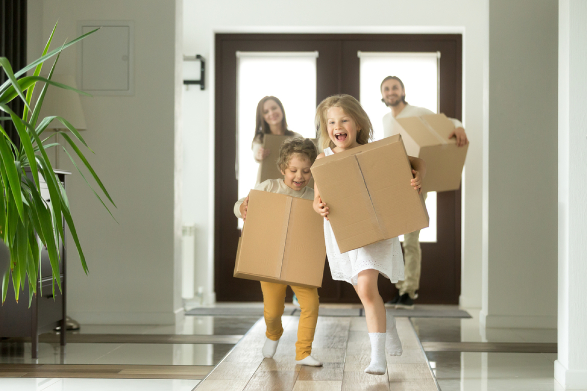 TVA réduite immobilier neuf – des enfants courent avec des cartons dans leur nouvelle maison