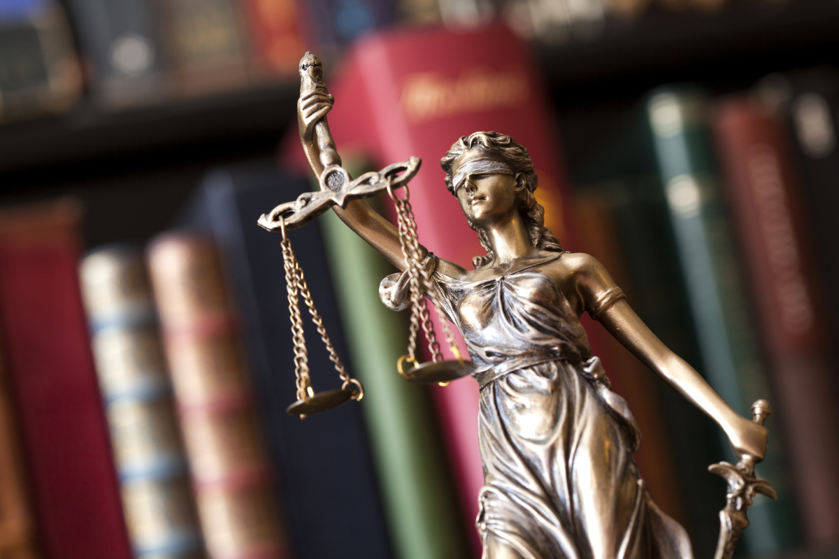 Remboursement caution locataire – Une statue représentant la justice devant des livres de droit