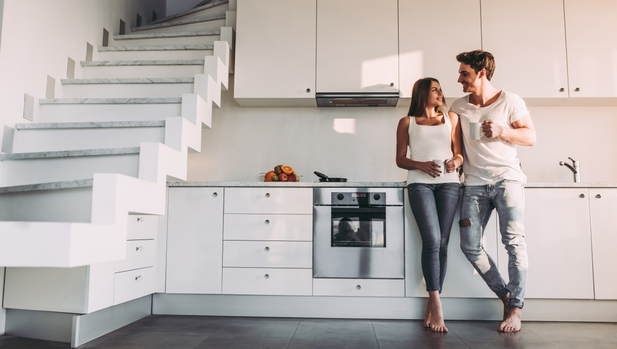 Typologie d'appartement – Un couple heureux à côté de l’escalier de son duplex