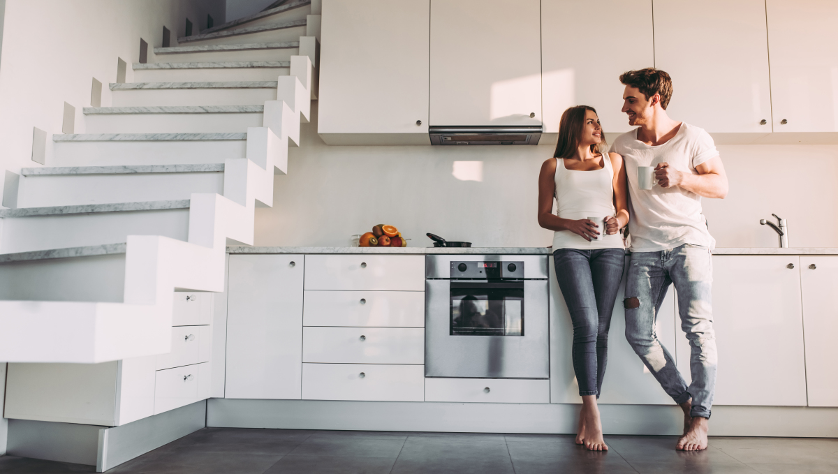 Le duplex avec jardin donne l’impression de vivre dans une véritable maison en pleine ville Typologie d'appartement – Un couple heureux à côté de l’escalier de son duplex