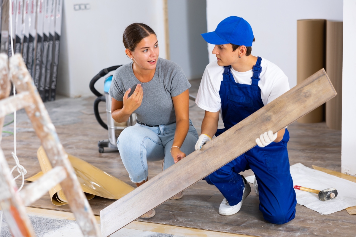 Quels sont les travaux éligibles aux déductions d'impôt ? une femme se tient au côté d'un artisan qui réalise des travaux dans son bien