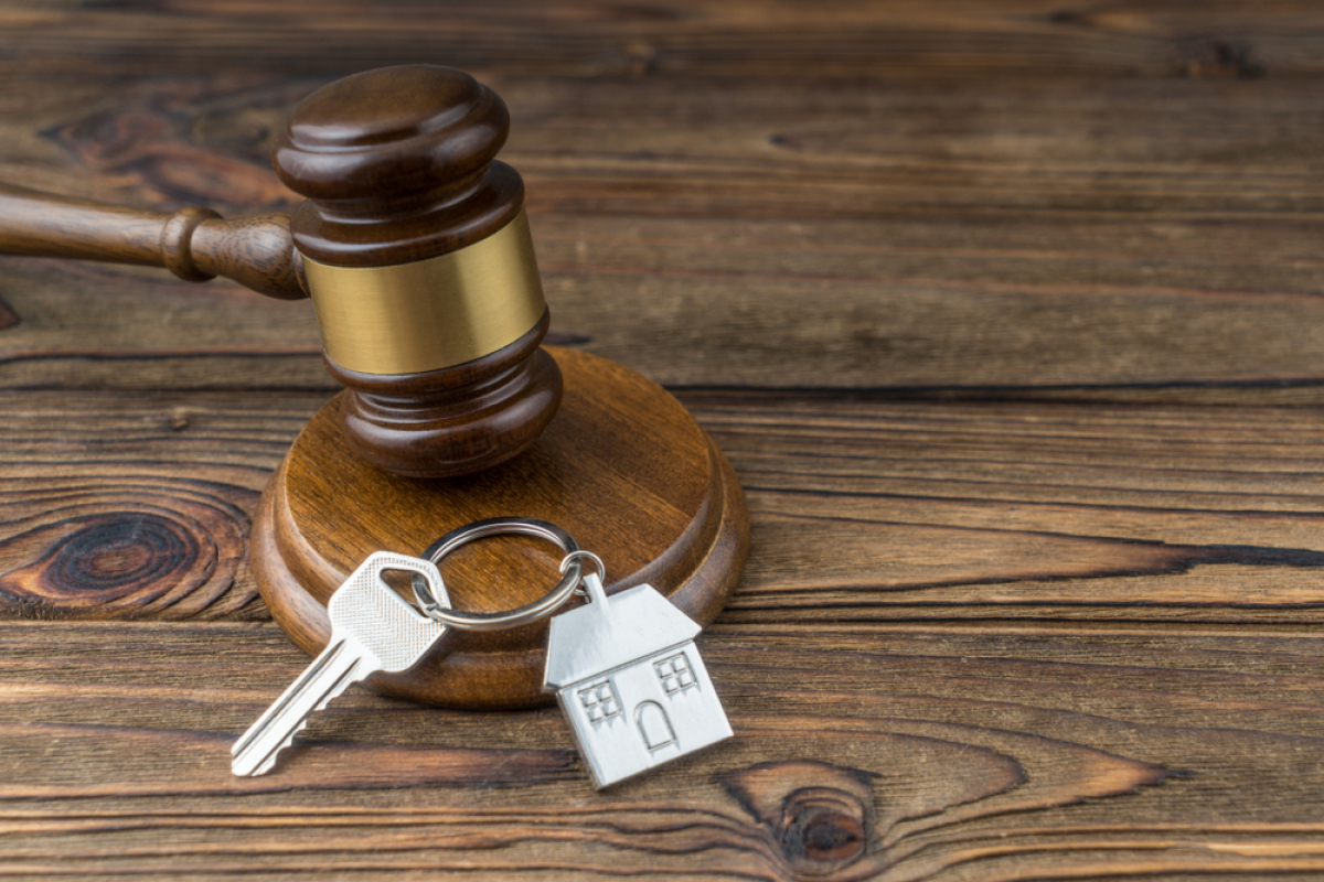 Comment donner congé à son locataire ? – Un marteau de juge posé à côté de clés de maison