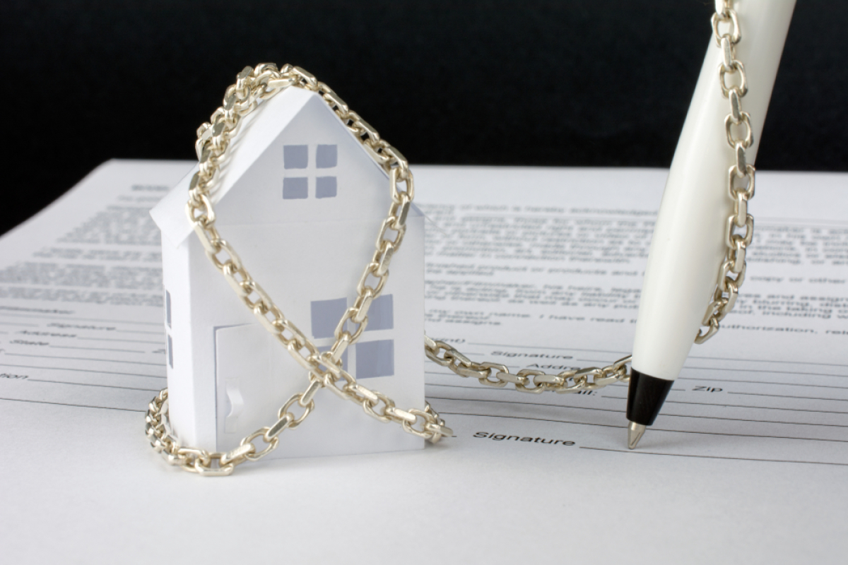 encadrement des loyers – un stylo enchaîné à une maison sur un contrat