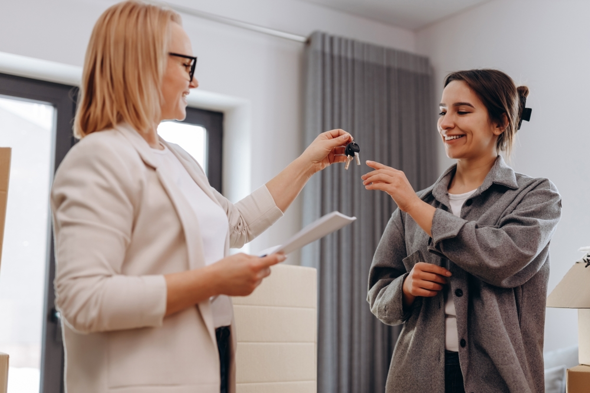 une propriétaire donne les clés de son appartement à une jeune locatire