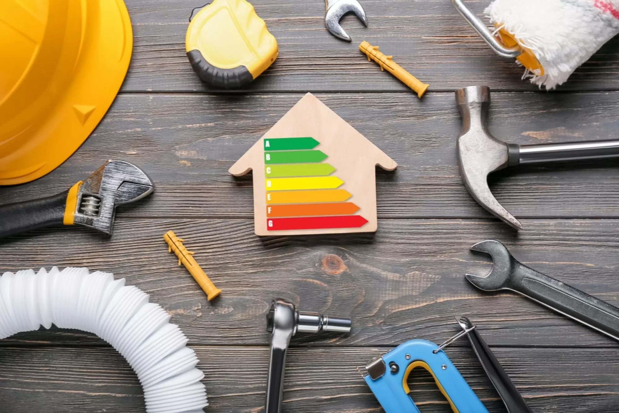 une maison en bois avec un DPE entourée par des outils