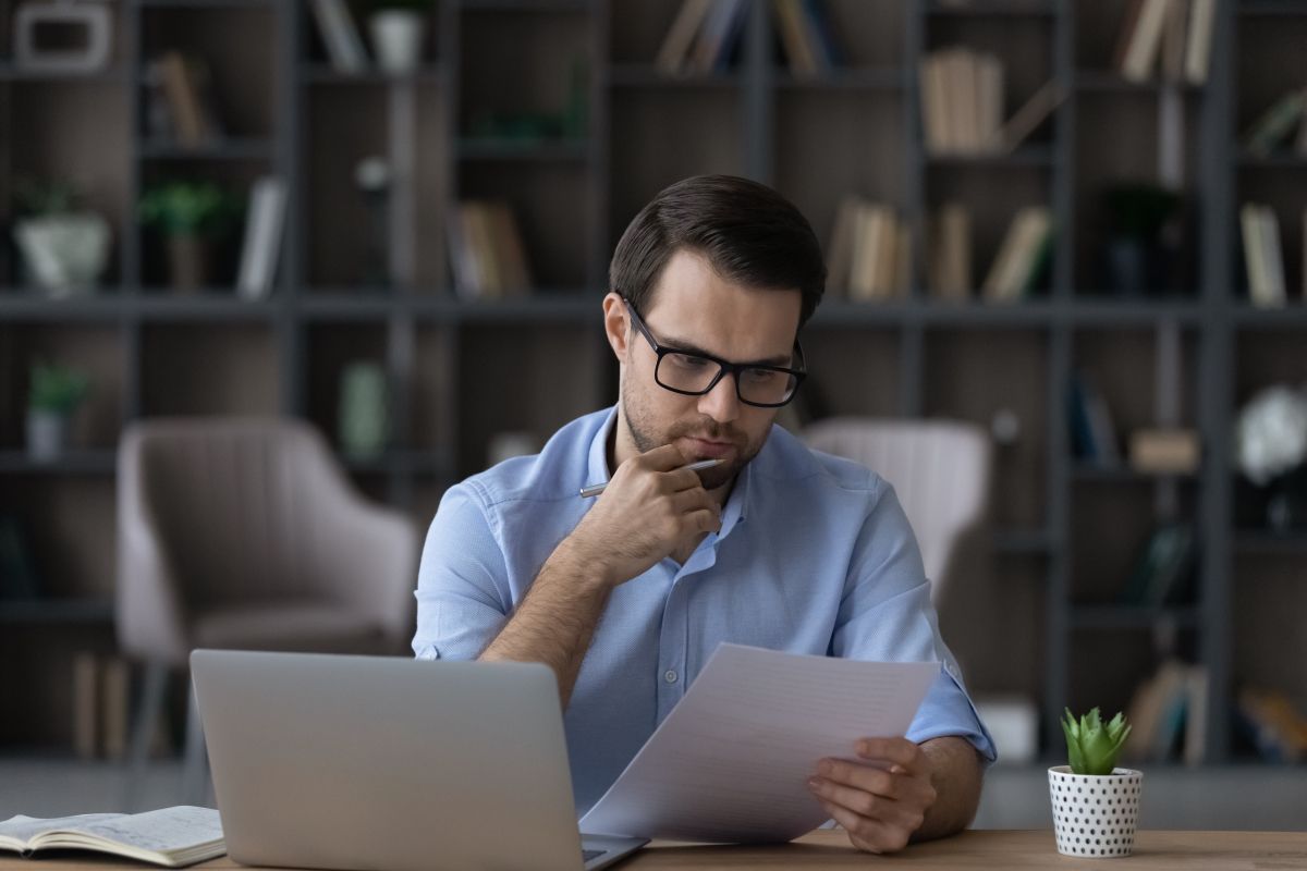 Frais intercalaires VEFA — Un homme se posant des questions en étudiant des documents