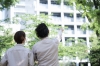 un couple montrant du doigt un immeuble neuf