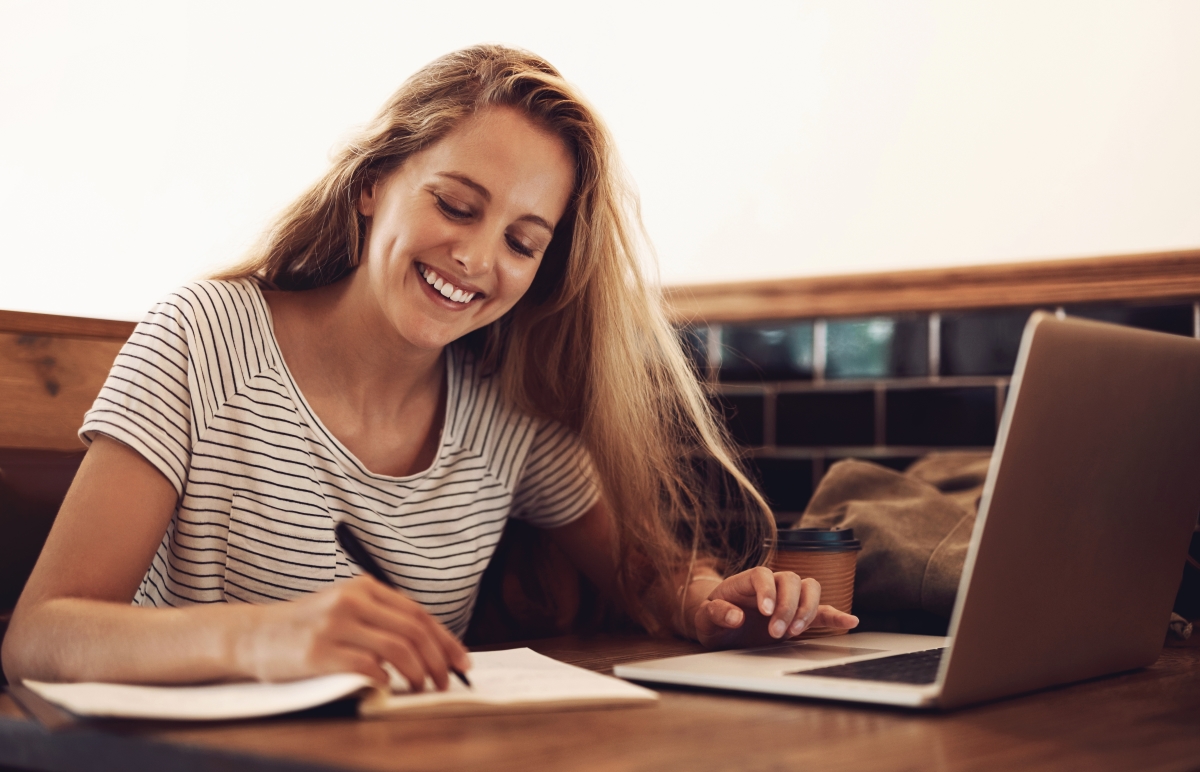 une jeune étudiante souriante dans une bibliothèque