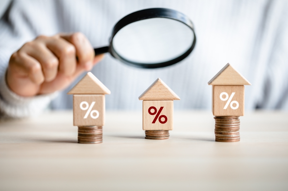 Bordeaux enregistre une baisse de prix par rapport à l’année dernière chiffres FPI immobilier neuf bordeaux 2T2024 – une loupe sur 3 maisons en bois posées sur des piles de pièces