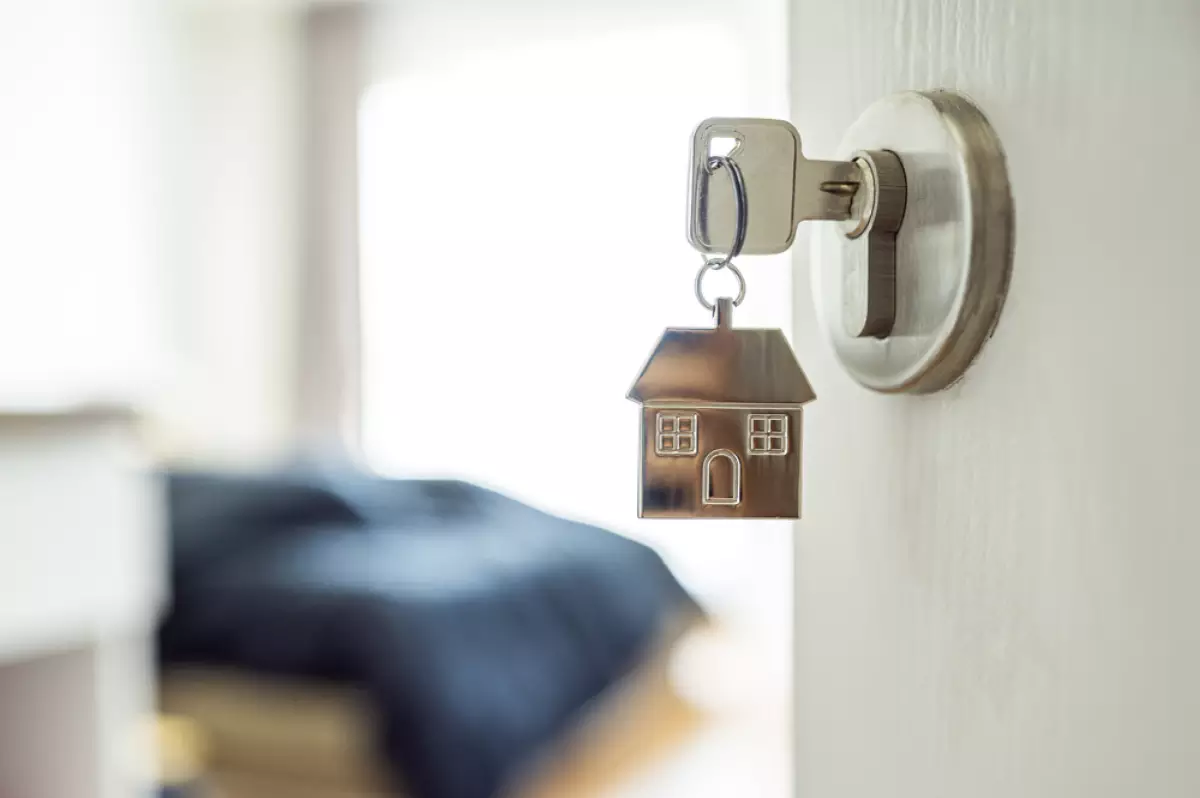 un porte clé en forme de maison pend à une porte