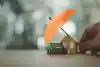 un parapluie devant une maquette de maison et de voiture